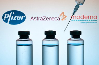 Carrara, İtalya - 05 Şubat 2021 - Arka planda bulanık Pfizer, Astrazeneca ve Moderna logolarına sahip covid-19 aşısı şişeleri bulanıklaştı