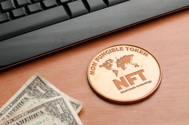 Nft (ödenebilir olmayan jeton) kavramı: bir bilgisayar klavyesi ve iki dolarlık banknotları olan ahşap bir masanın üzerindeki büyük bakır para