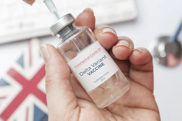 医者はデルタ変異体から免疫するためにCovid 19ワクチンの仮説上のバイアルを保持している — ストック写真