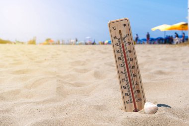 Wooden thermometer buried in the sand of an Italian beach show temperature both in Celsius and Fahrenheit scale clipart