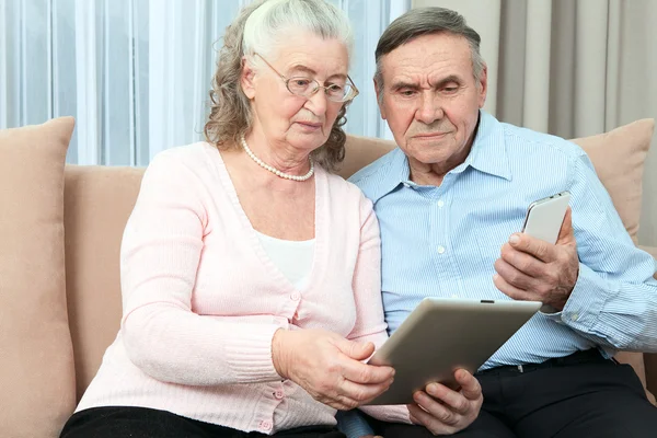 Elderly couple holding laptop — Stock Photo, Image