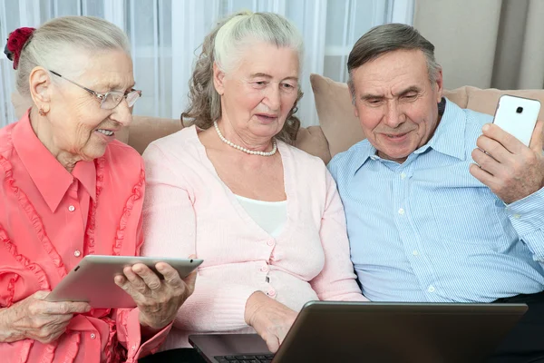 Grupo de pessoas idosas segurando um laptop — Fotografia de Stock