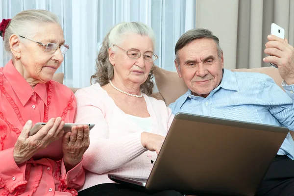 Grupo de pessoas idosas segurando um laptop — Fotografia de Stock