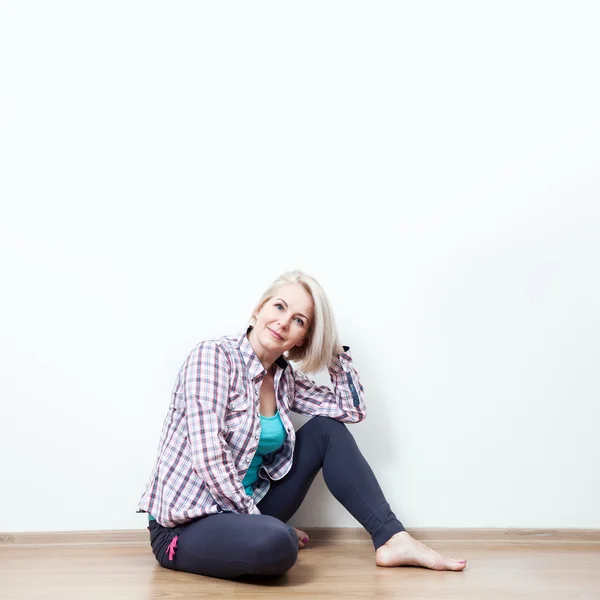 Donna felice seduta sul pavimento — Foto Stock