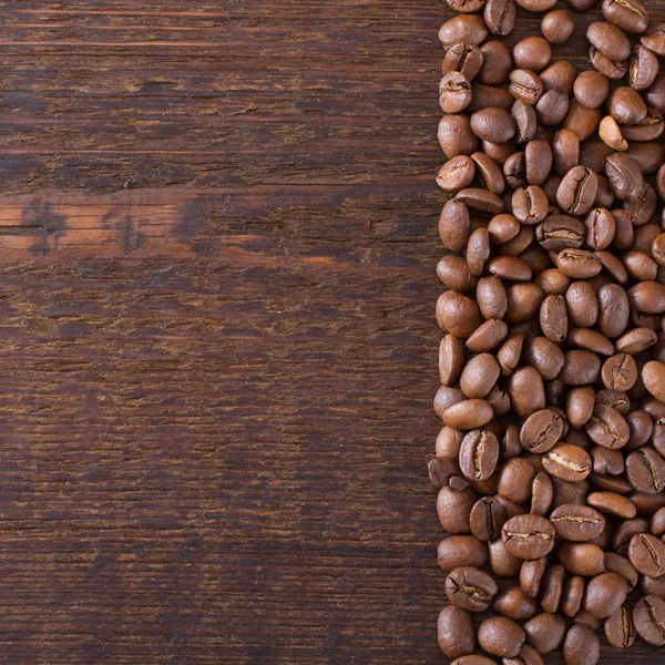 Grãos de café em fundo de madeira. — Fotografia de Stock