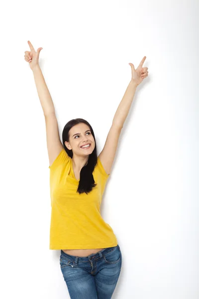 Portrait of cheerful European woman with hands raised pointing up — Stock Photo, Image