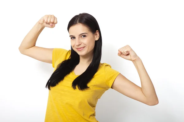 Sterke vrouw. Mooi meisje toont haar gespierdheid, camera kijken — Stockfoto