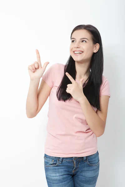 Vriendelijk lachende vrouw wijzend op copyspace geïsoleerd op witte achtergrond — Stockfoto