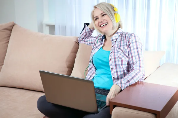 Beautiful woman in bright outfit enjoying music at home — Stock Photo, Image