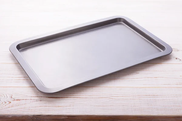 Empty baking tray on white wooden desk — Stock Photo, Image