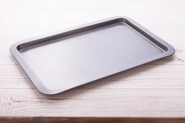 Empty baking tray on white wooden desk Royalty Free Stock Images