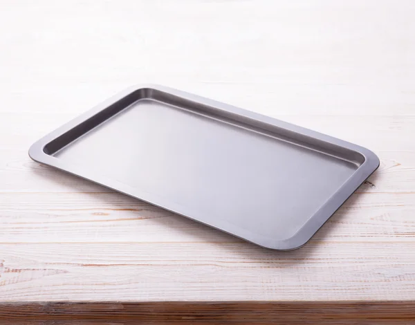 Empty baking tray on white wooden desk Stock Image