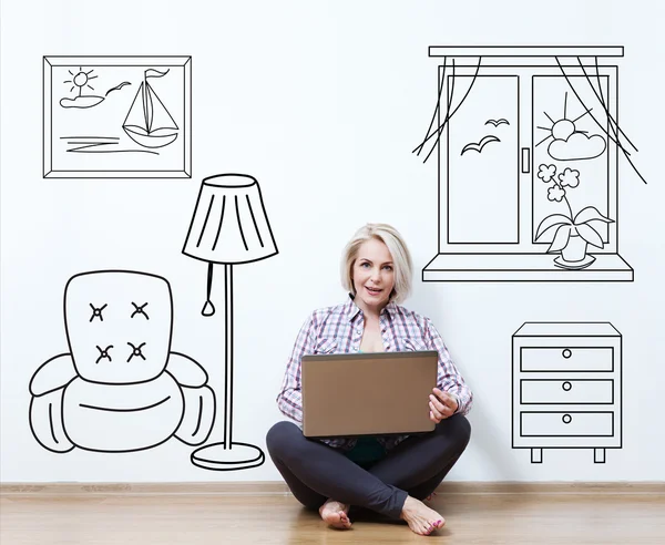 Smiling woman sitting on floor with laptop, considering new idea — Stock Photo, Image