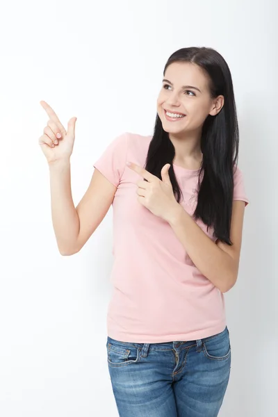 Vriendelijk lachende vrouw wijzend op copyspace geïsoleerd op witte achtergrond — Stockfoto