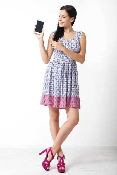 Retrato de una hermosa mujer joven sosteniendo un teléfono inteligente sobre fondo blanco —  Fotos de Stock