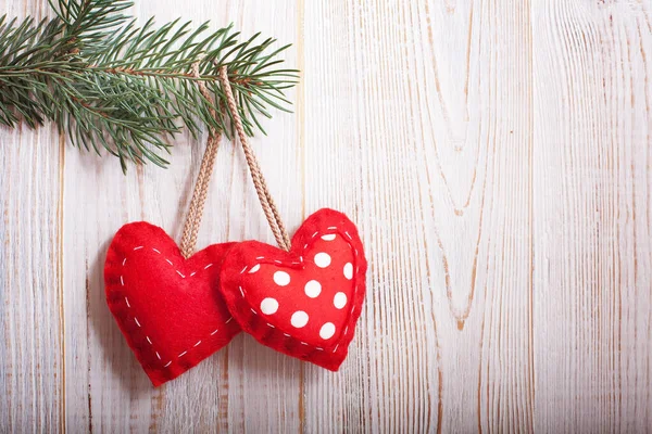 Vánoční hračky, červená srdce a vánoční větev na dřevěném stole — Stock fotografie