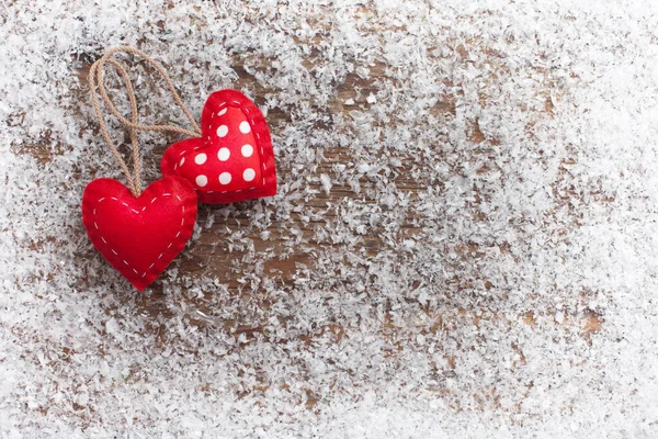 Juguetes de Navidad, corazones rojos y nieve en escritorio de madera — Foto de Stock