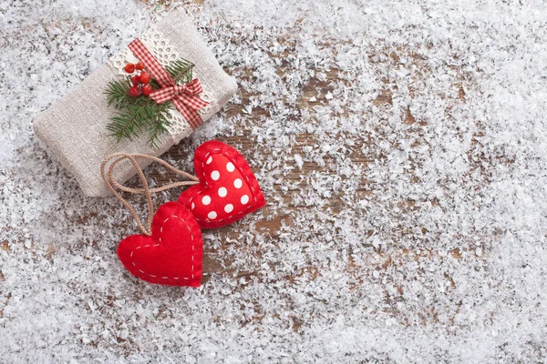 La confezione regalo è decorata con cuori e ramo di Natale sulla scrivania in legno con neve — Foto Stock