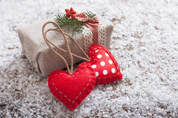 La confezione regalo è decorata con cuori e ramo di Natale sulla scrivania in legno con neve — Foto Stock