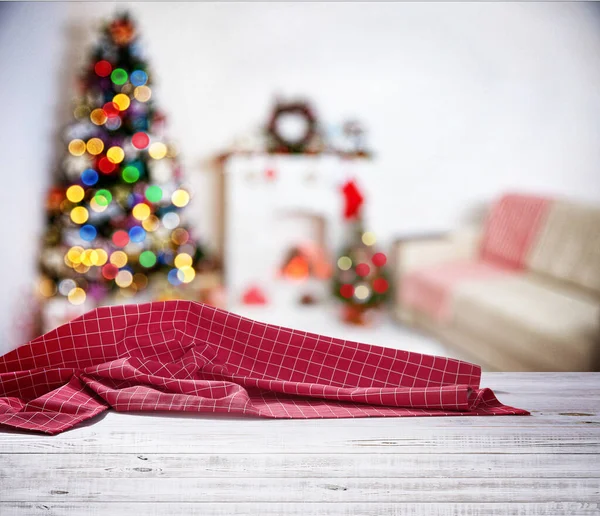 Servilleta roja sobre mesa de madera y fondo navideño. — Foto de Stock