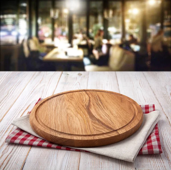 Napkin and pizza board on wooden desk top view mock up. Pizzeria interior. Selective focus. — Stock Photo, Image