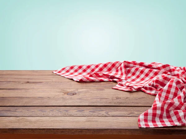 Toalha de mesa quadriculada vermelha na mesa de madeira. Guardanapo perto vista superior zombar. Cozinha rústico fundo. — Fotografia de Stock