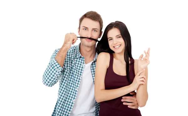 Bonito casal jovem se unindo uns aos outros e sorrindo ao fazer um bigode falso de seu cabelo — Fotografia de Stock