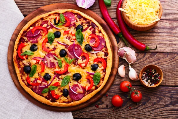 Pizza mit Schinken, Pfeffer und Oliven. leckere frische Pizza auf Holztisch serviert. — Stockfoto