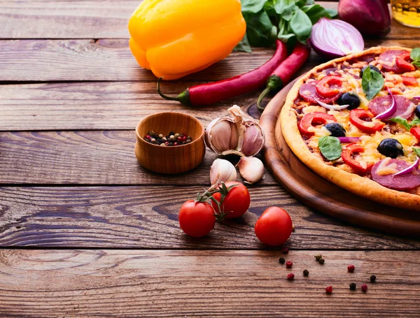 Pizza mit Schinken, Pfeffer und Oliven. leckere frische Pizza auf Holztisch serviert. — Stockfoto