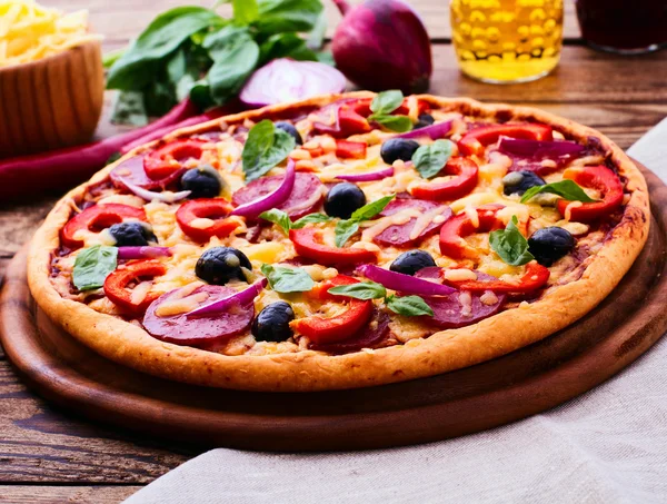Pizza con jamón, pimienta y aceitunas. Deliciosa pizza fresca servida en mesa de madera . —  Fotos de Stock