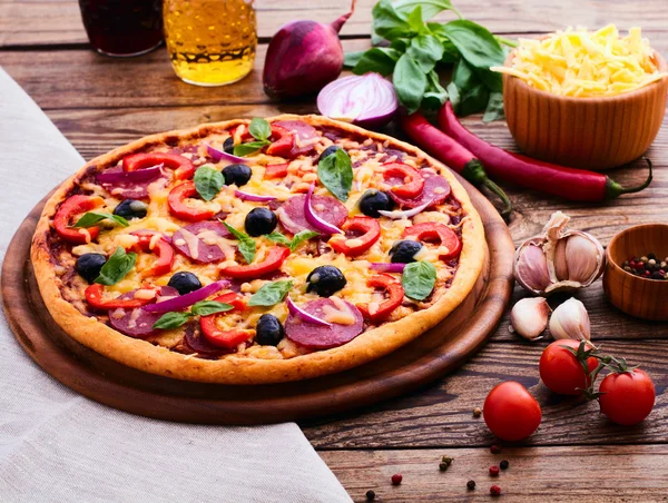 Pizza mit Schinken, Pfeffer und Oliven. leckere frische Pizza auf Holztisch serviert. — Stockfoto
