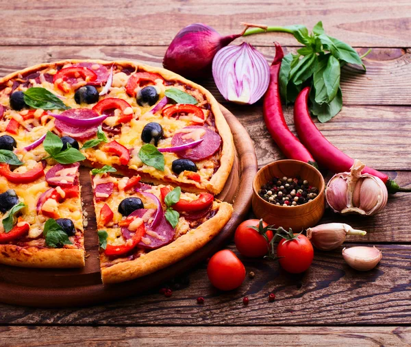 Pizza with ham, pepper and olives. Delicious fresh pizza served on wooden table. — Stock Photo, Image