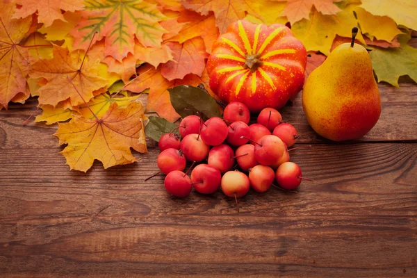 Hojas de otoño sobre mesa de madera. Frutas y hortalizas . — Foto de Stock