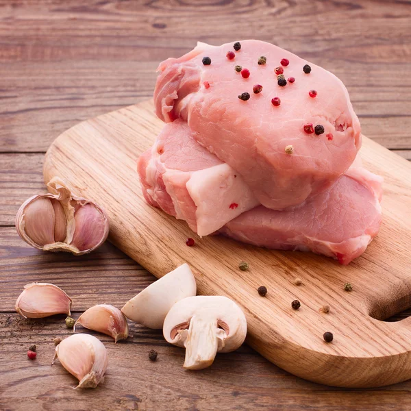 Alimentos fatiados pedaços de carne crua para churrasco com legumes frescos e cogumelos na superfície de madeira . — Fotografia de Stock