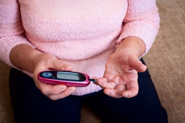 Vrouw testen voor hoge bloedsuikerspiegel. — Stockfoto