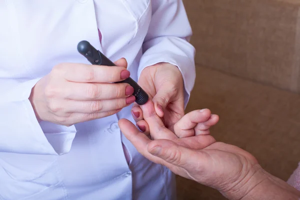 Nurse takes test for sugar in blood of elderly woman at home — Stock Photo, Image