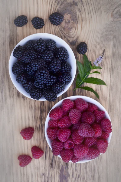 Schalen voller Sommerbeeren wie Himbeeren und Brombeeren. — Stockfoto