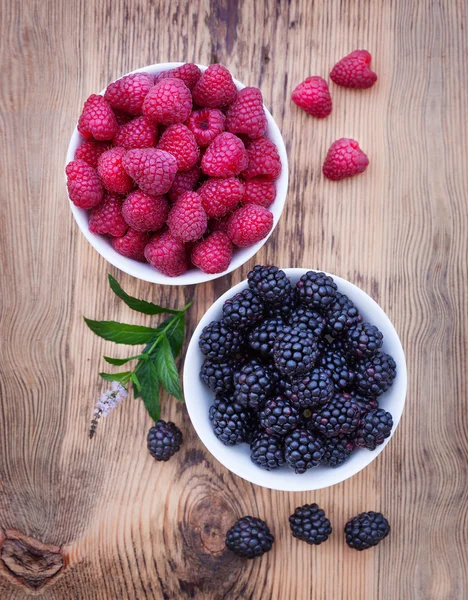 Schalen voller Sommerbeeren wie Himbeeren und Brombeeren. — Stockfoto