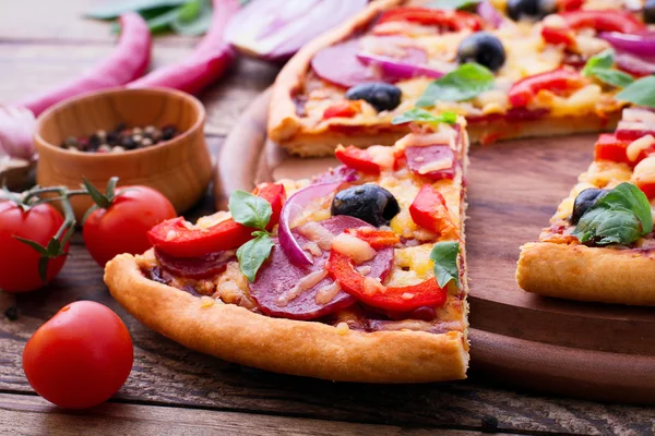 Delicious pizza served on wooden table — Stock Photo, Image