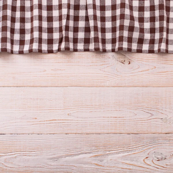 Top view of checkered tablecloth on white wooden table. — Stock Photo, Image