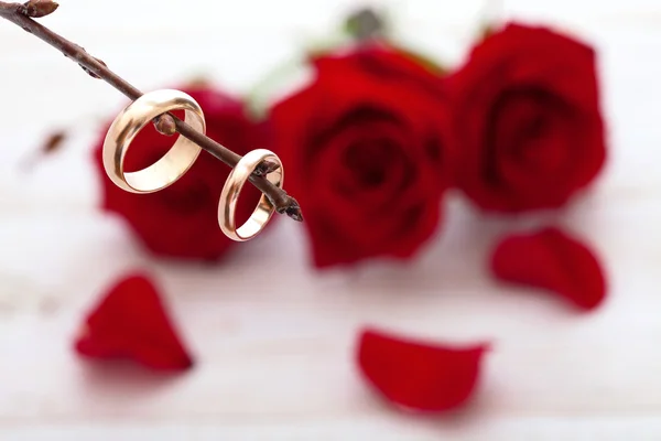 Anelli da sposa e bouquet da sposa di petali di rose rosse . — Foto Stock