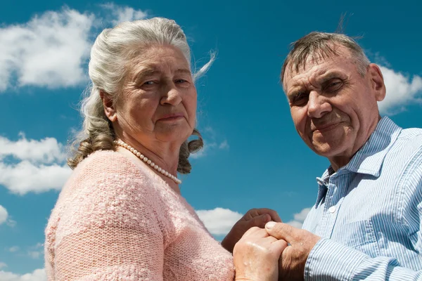 Äldre par omfamnar varandra på landsbygden — Stockfoto