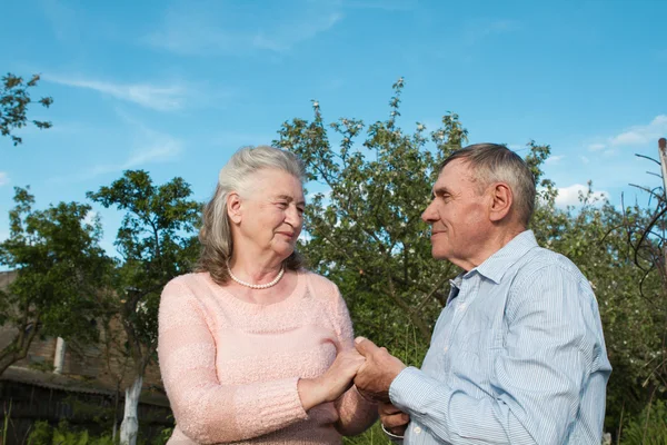 Pareja mayor abrazándose en el campo — Foto de Stock