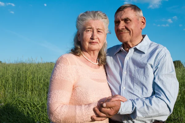 Старша пара обіймає один одного в сільській місцевості — стокове фото