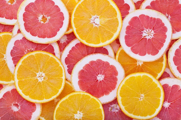 Anillos de naranja y pomelo como fondo — Foto de Stock