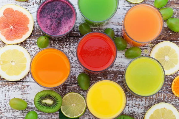 Gläser mit leckerem frischen Saft, auf Holztisch. — Stockfoto