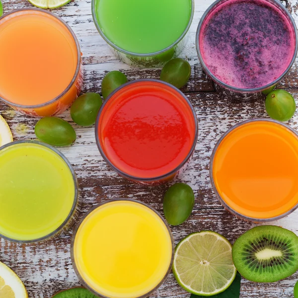 Copos de suco fresco saboroso, na mesa de madeira . — Fotografia de Stock