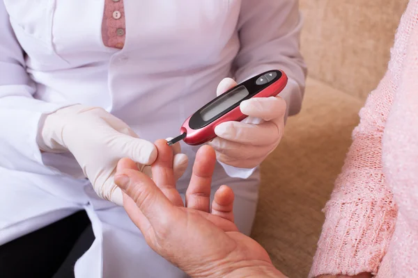 Nurse takes test for sugar in blood of elderly woman at home. — Stock Photo, Image