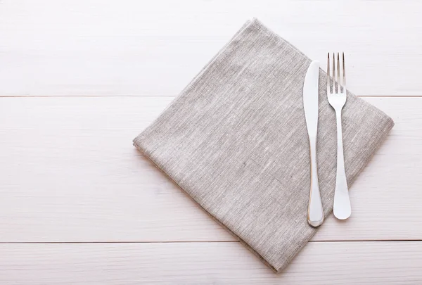Příbory, ubrusy na bílý dřevěný stůl na večeři. — Stock fotografie