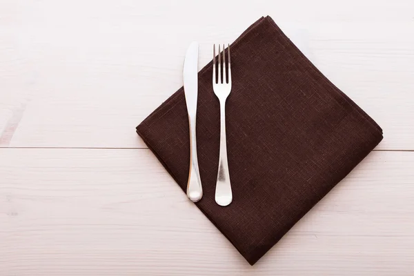 Μαχαιροπήρουνα, τραπεζομάντιλο στο λευκό ξύλινο τραπέζι για δείπνο. — Φωτογραφία Αρχείου